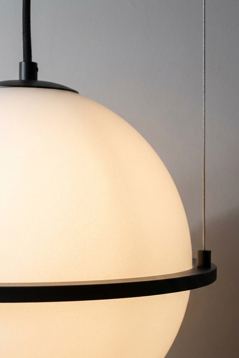 Close-up of the white globe shade with black top cap and black metal ring