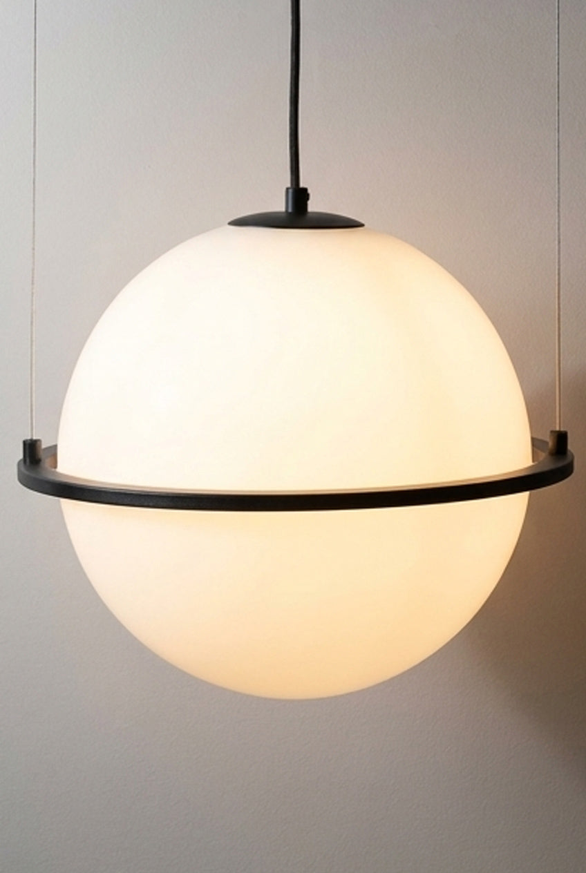 white sphere pendant light with a warm glow and black metal ring detail