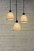 A 3-drop light chandelier featuring small ceramic shades and a black pendant cord.