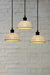A 3-drop light chandelier featuring large ceramic shades and a black pendant cord.