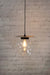small clear pendant light with black disc