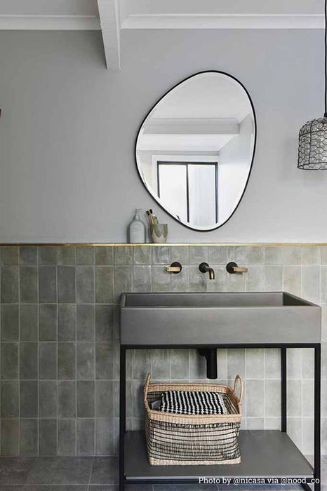 Glass and wire pendant hanging over bathroom basin