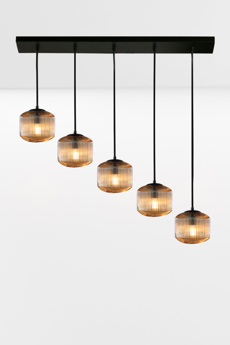 5 drop linear light with amber reeded glass shades in a diagonal configuration.