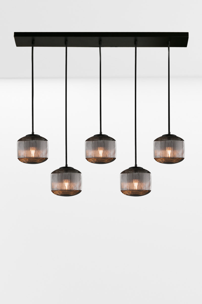 5 drop linear light with grey reeded glass shades in a staggared formation. 