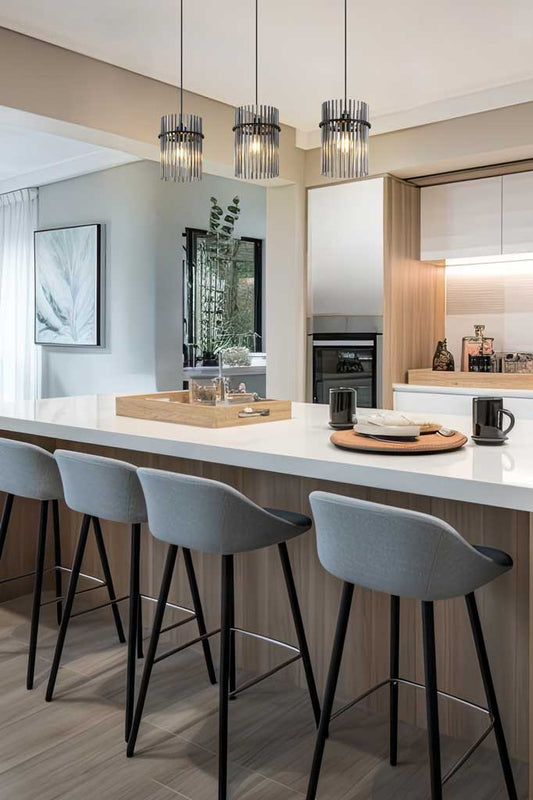 Three light pendant with smoke glass rod shades hanging in a neural kitchen. 