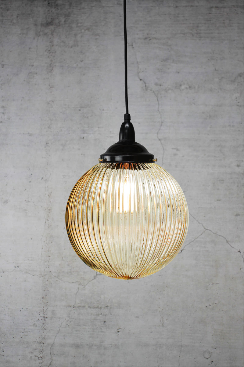 Medium sized Amber reeded glass ball shade on a black IP rated pendant cord.