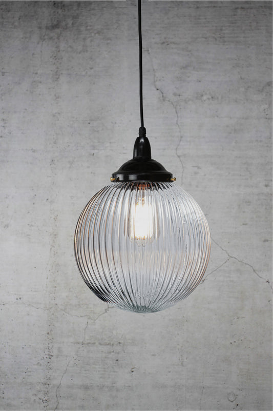 Medium sized clear reeded glass ball shade on a black IP rated pendant cord.