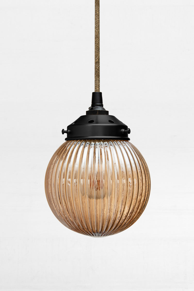 Dark Amber reeded glass ball shade on a jute pendent cord with black metalware. 