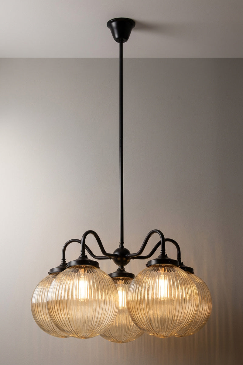 5 arm chandelier with gooseneck style arms in black with medium amber reeded glass ball shades. 