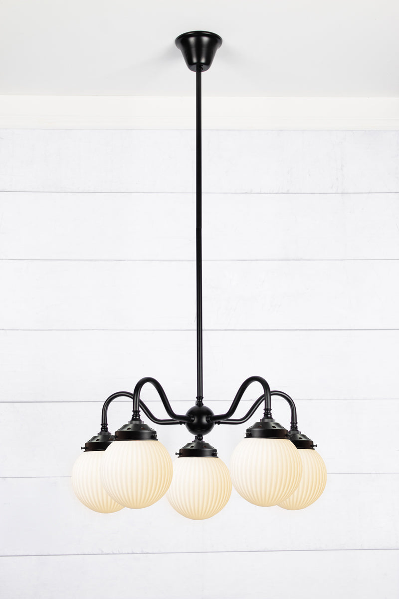 5 arm chandelier with gooseneck style arms in black with opal reeded glass ball shades. 