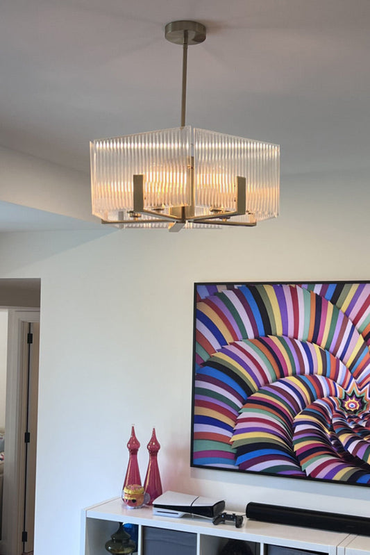Living room with a colorful abstract painting on the wall and a chandelier.