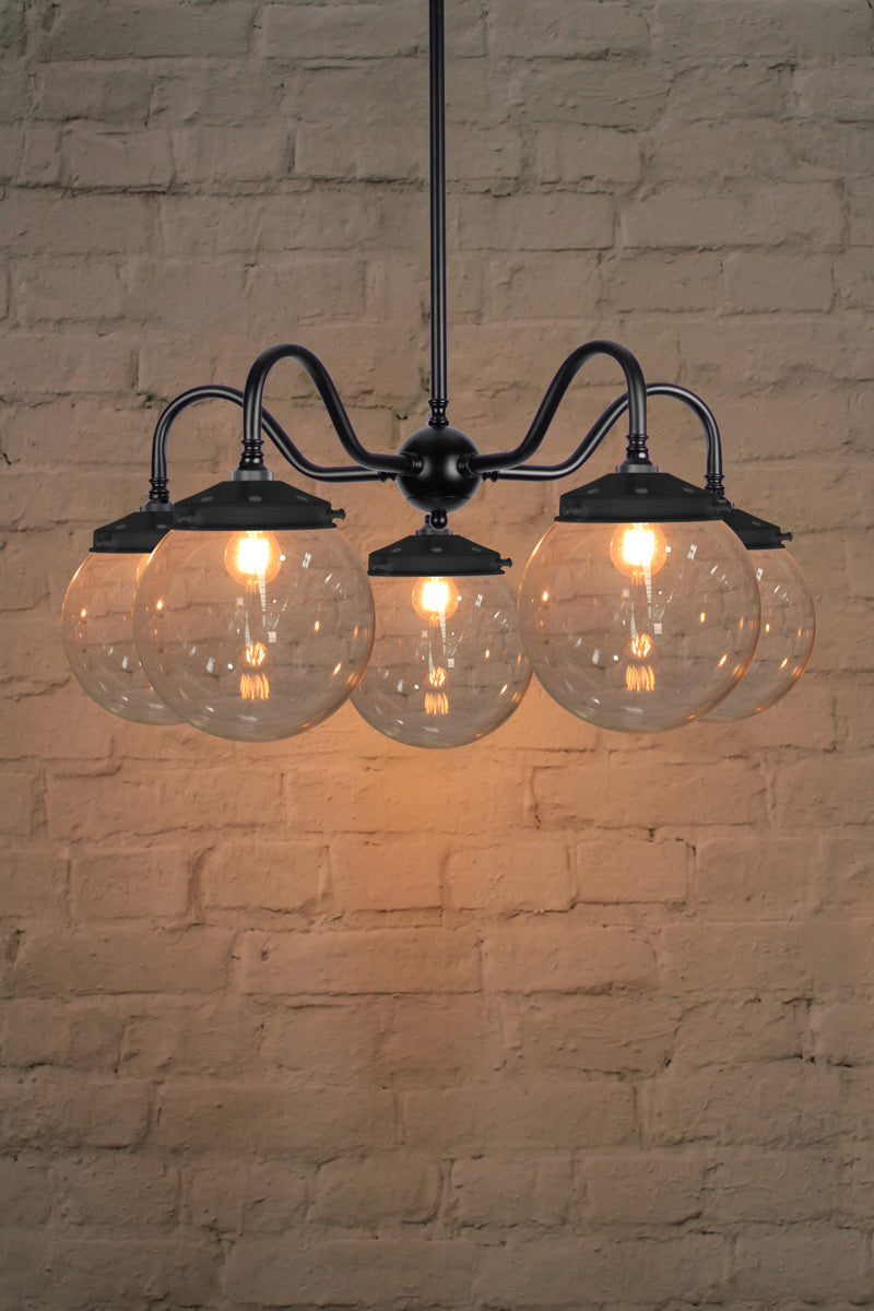 Medium, clear glass ball shades on a five arm black gooseneck chandelier fixture. 