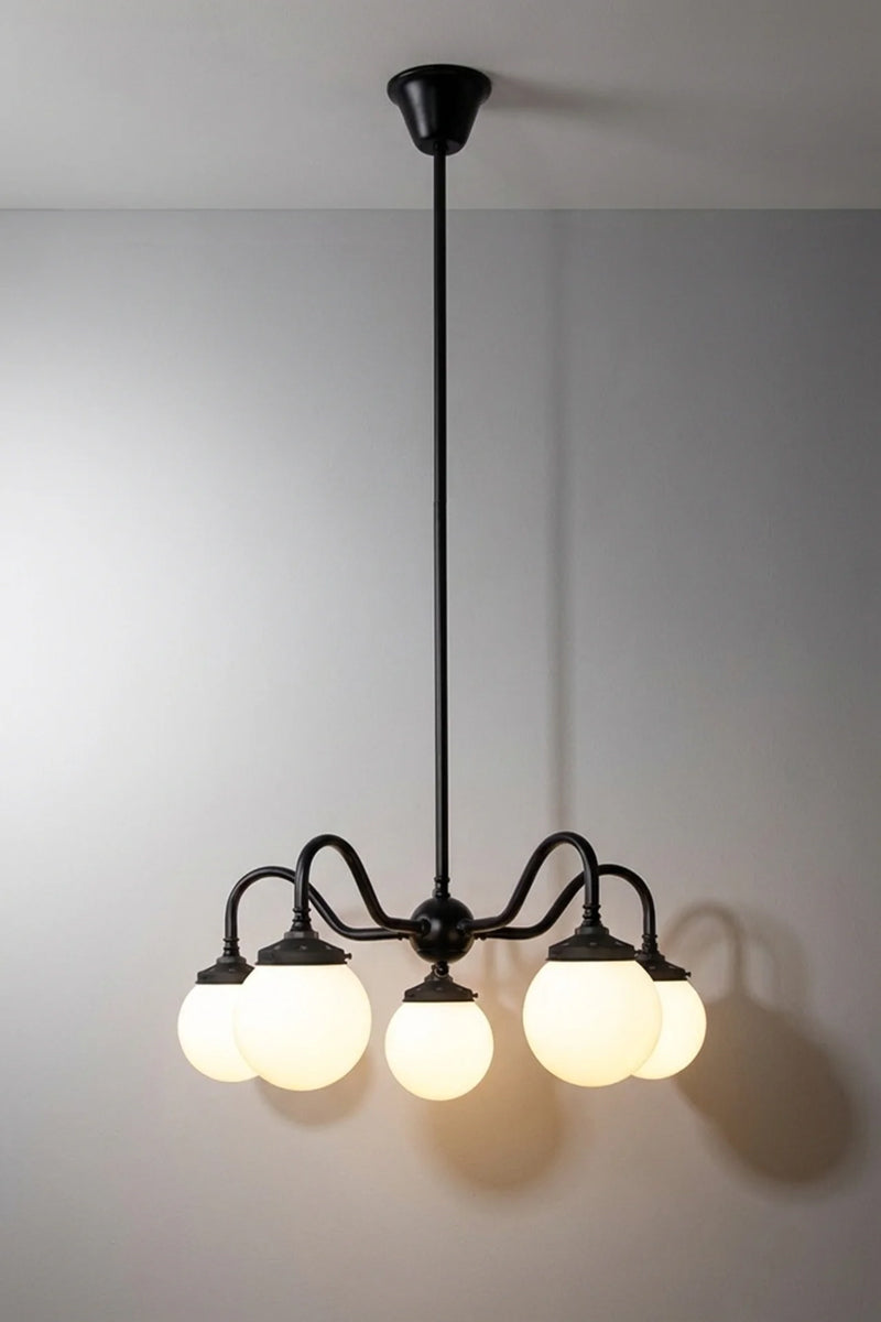 Small, opal glass ball shades on a five arm black gooseneck chandelier fixture. 
