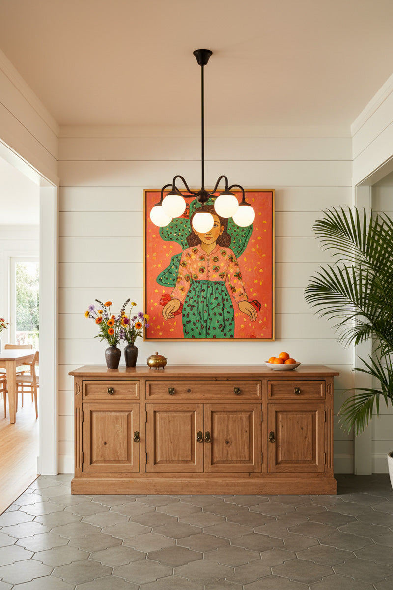Black five light pendant with opal glass globes on curved arms, hanging above a timber sideboard in a bright hallway