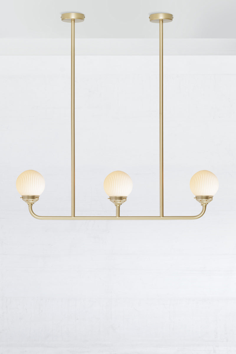 Gold/Brass five lamp linear chandelier with opal reeded glass ball shades. 