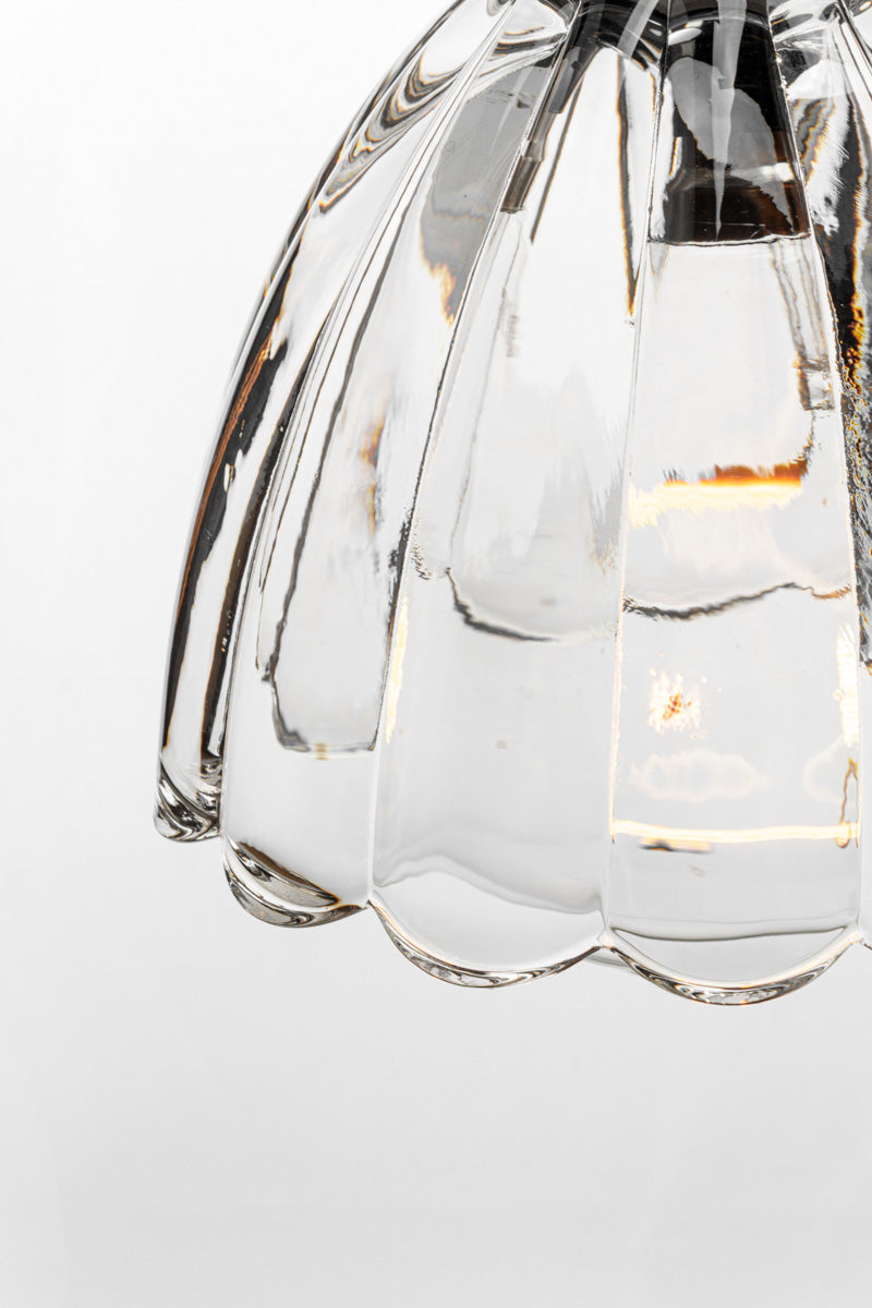 Close-up detail of the Monroe clear textured glass pendant shade showing sculptural contours and illuminated effect.