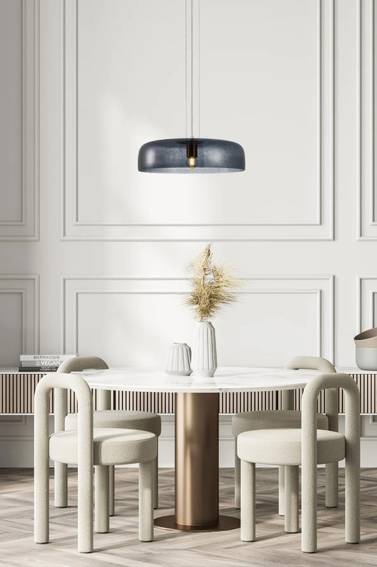 Single tiered smokey black glass pendant over a dining space. 