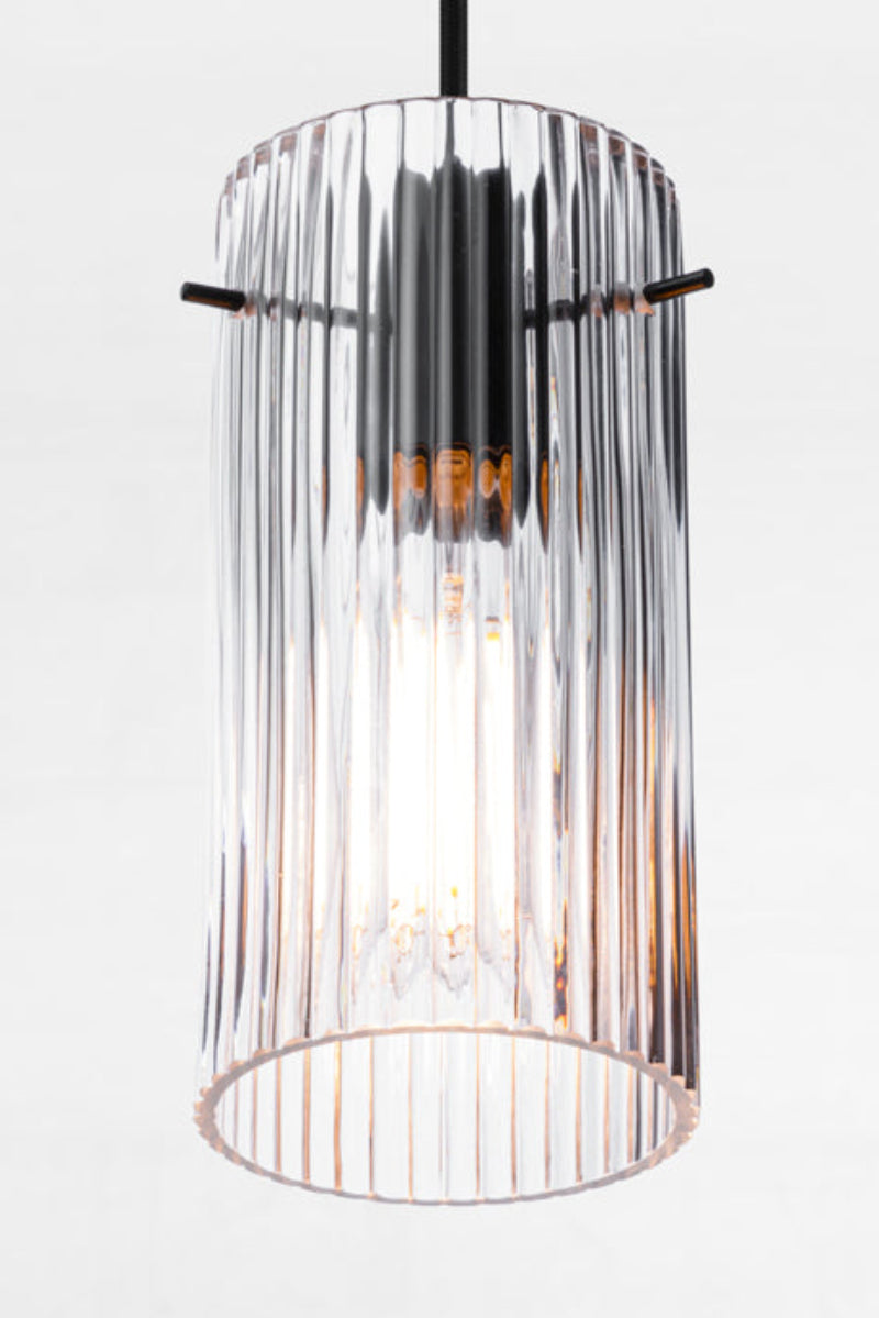 Reeded clear glass shade and black pendant cord. 