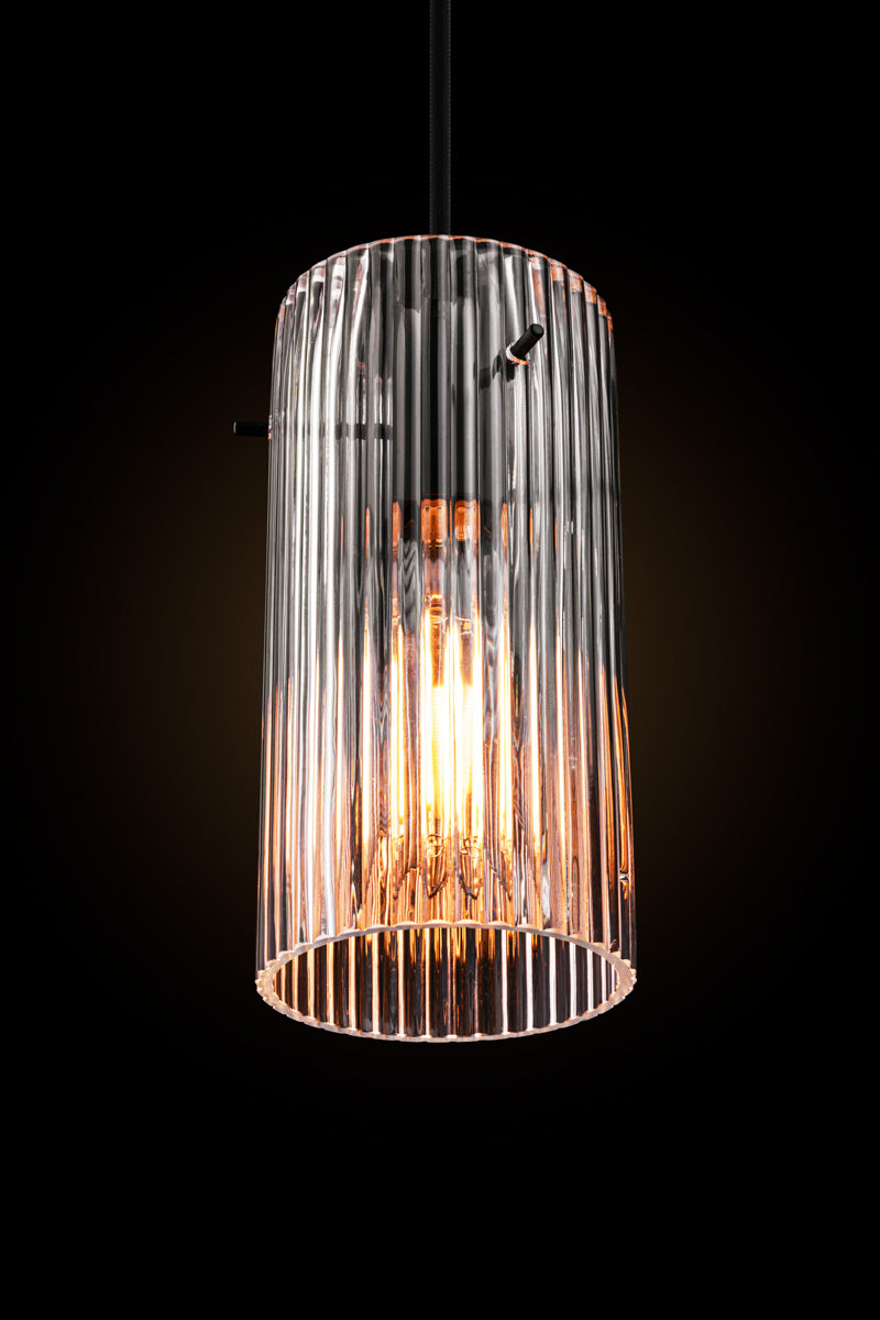 Indiana Glass Pendant Light featuring reeded clear glass and black pendant cord in a dark room to showcase shade detailing. 