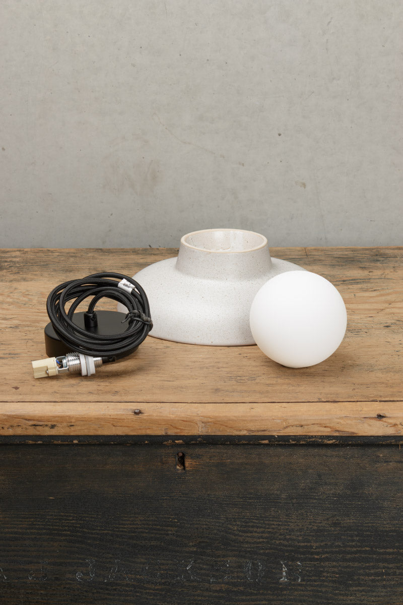 Uninstalled large ceramic pendant light with black cord and ceiling rose and an opal glass ball shade. 