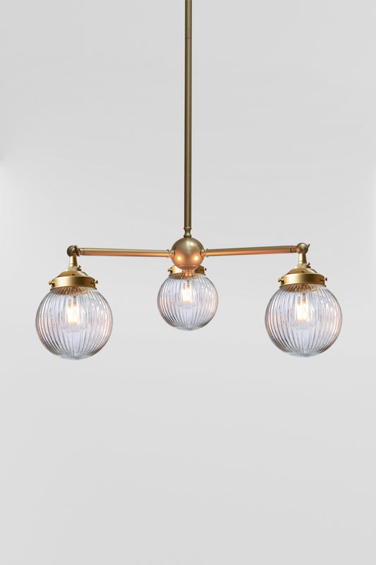 Gold/brass 3 light chandelier with swivel function with clear reeded glass ball shades. 