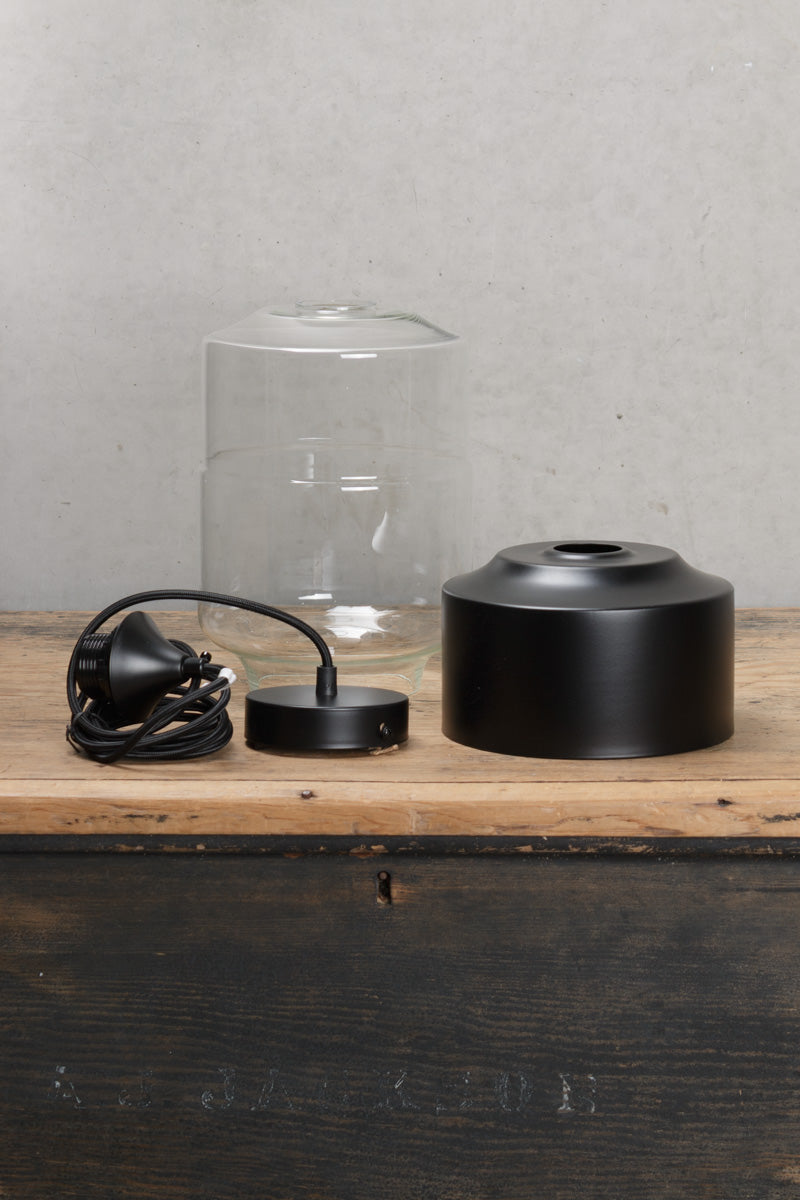 Uninstalled Silhuette B glass and metal pendant light, with black pendant cord. 