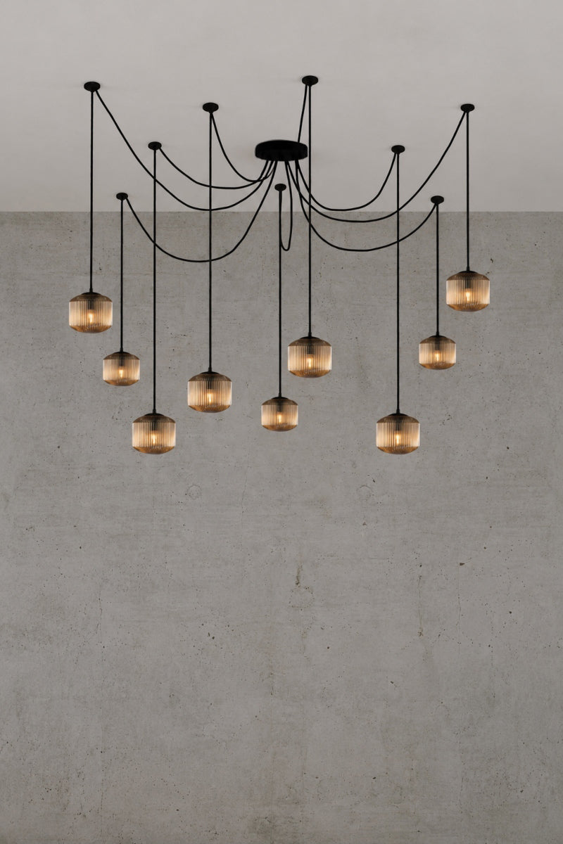9 drop chanderlier with amber, reeded glass shades and black cord and hardware. 