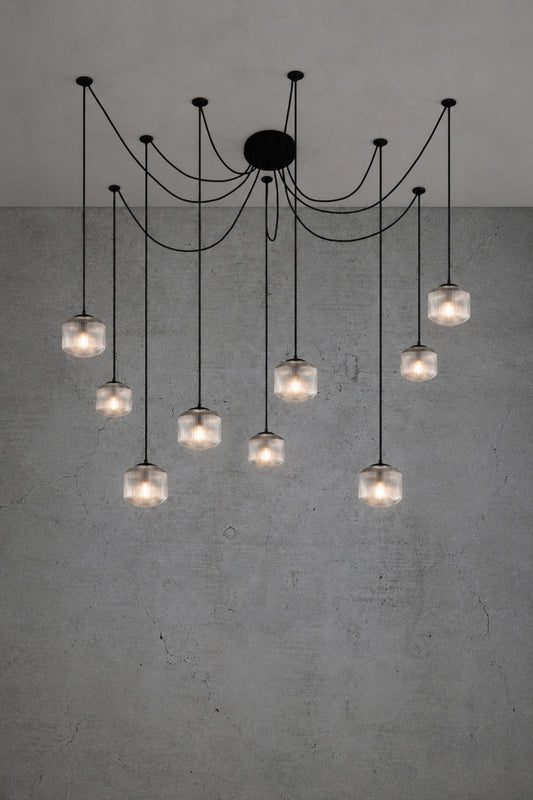 9 drop chanderlier with clear, reeded glass shades and black cord and hardware. 