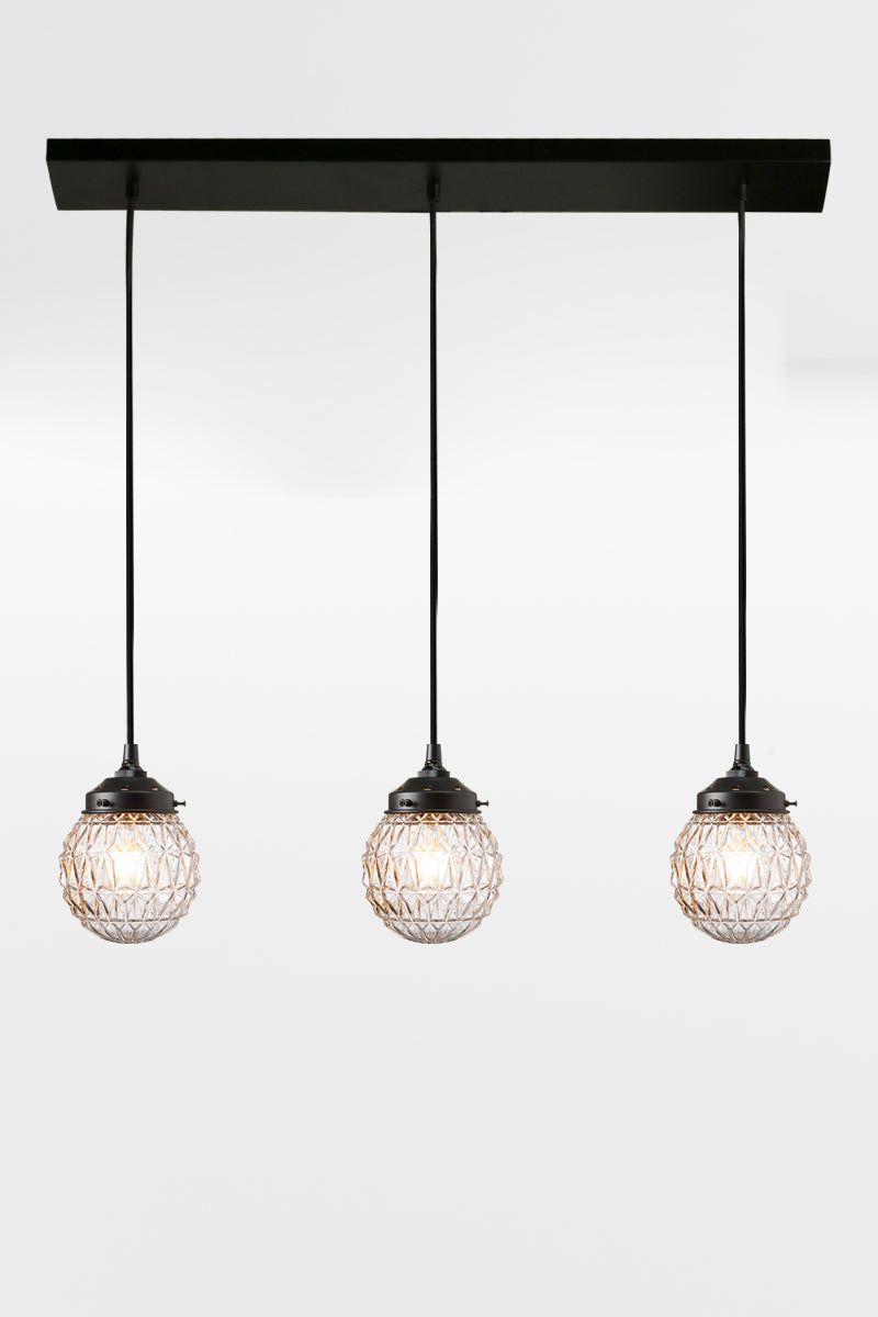 5 light mid-century modern linear light with clear textured glass and black fixture. 