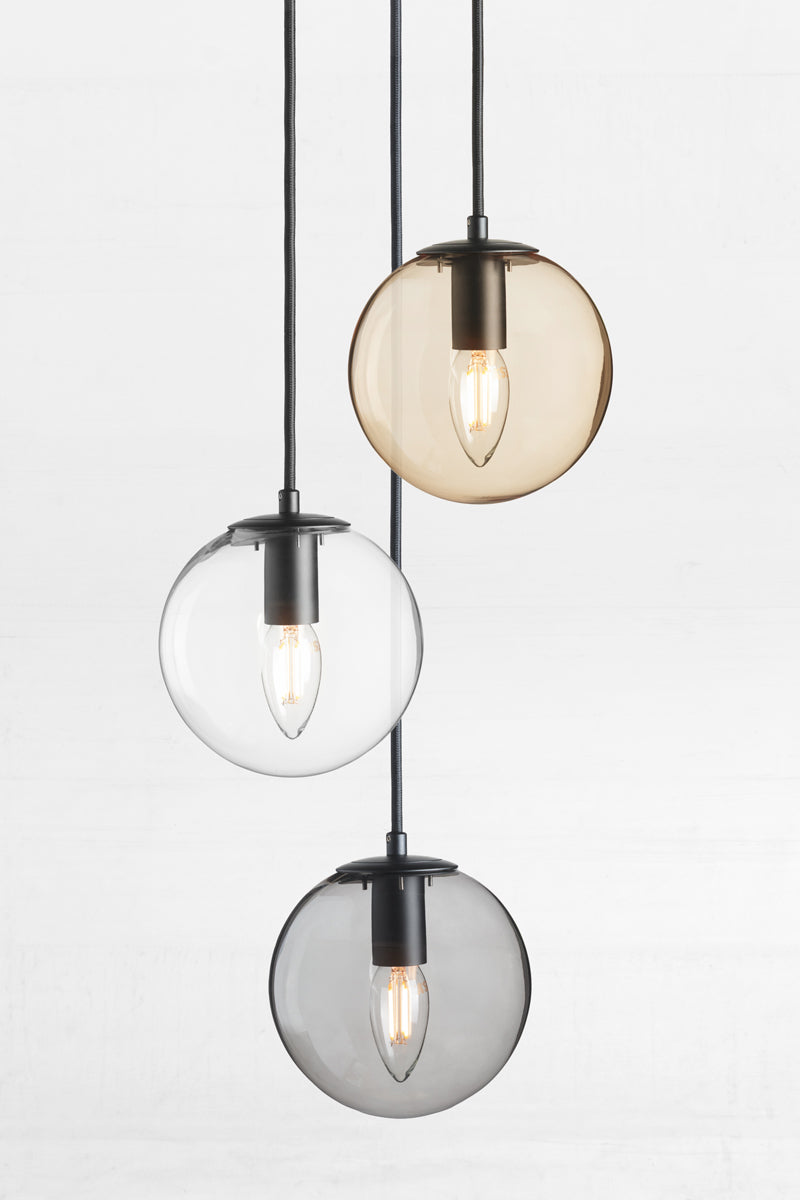 Three drop pendant with an amber, clear and grey orb glass shades. 