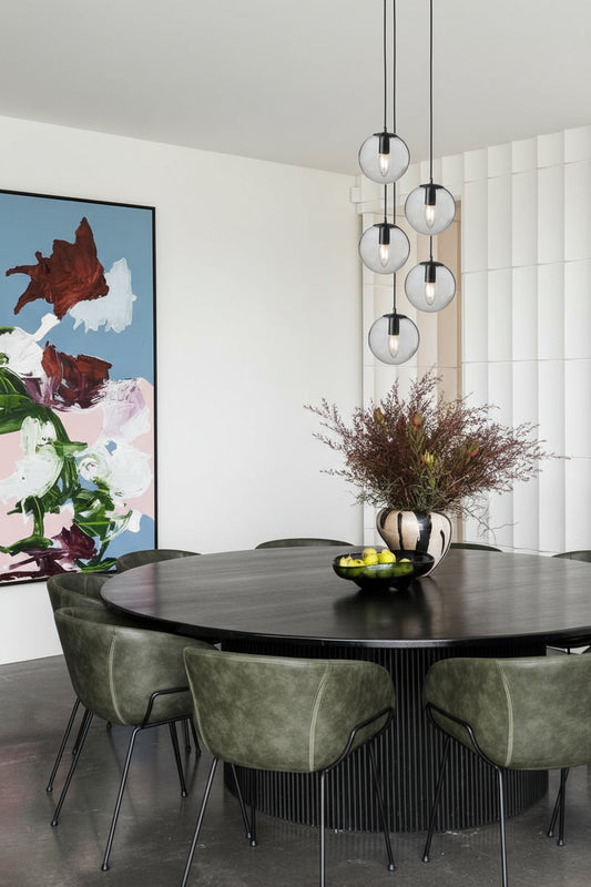 Five drop multi light with clear glass orb shades in a modern dining space. 