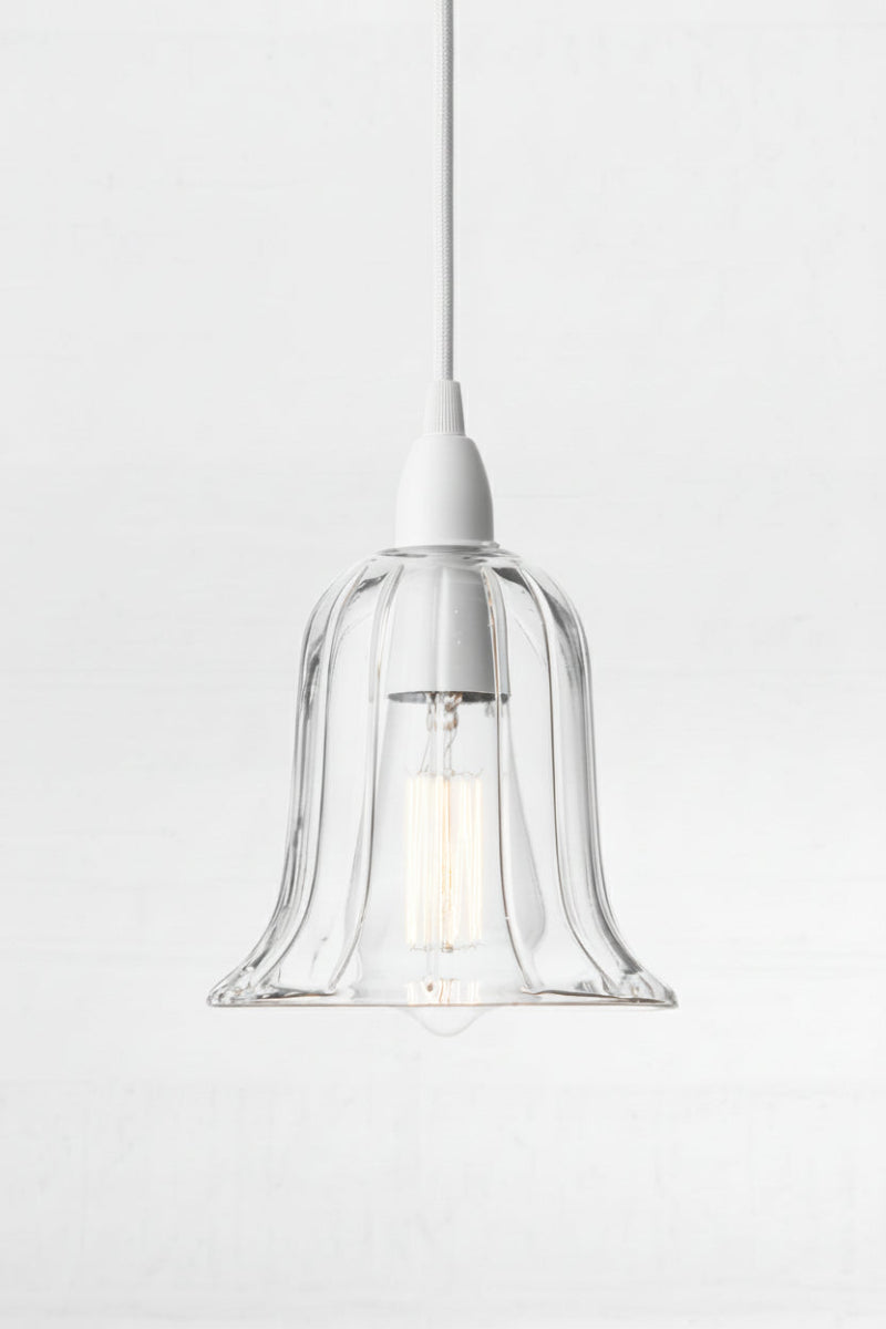 Clear glass bell shade paire with a white pendant cord. 