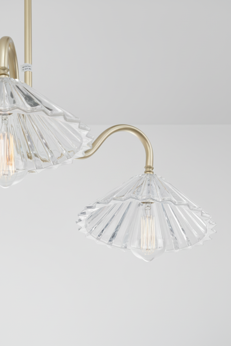Chandelier with clear glass shades and gold metal fixtures on a white ceiling.