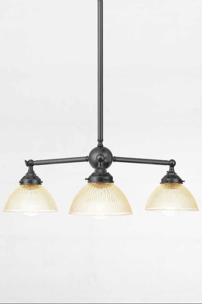 Three amber glass reeded shades with a plain edge, paired with a black finished triple arm fixture.