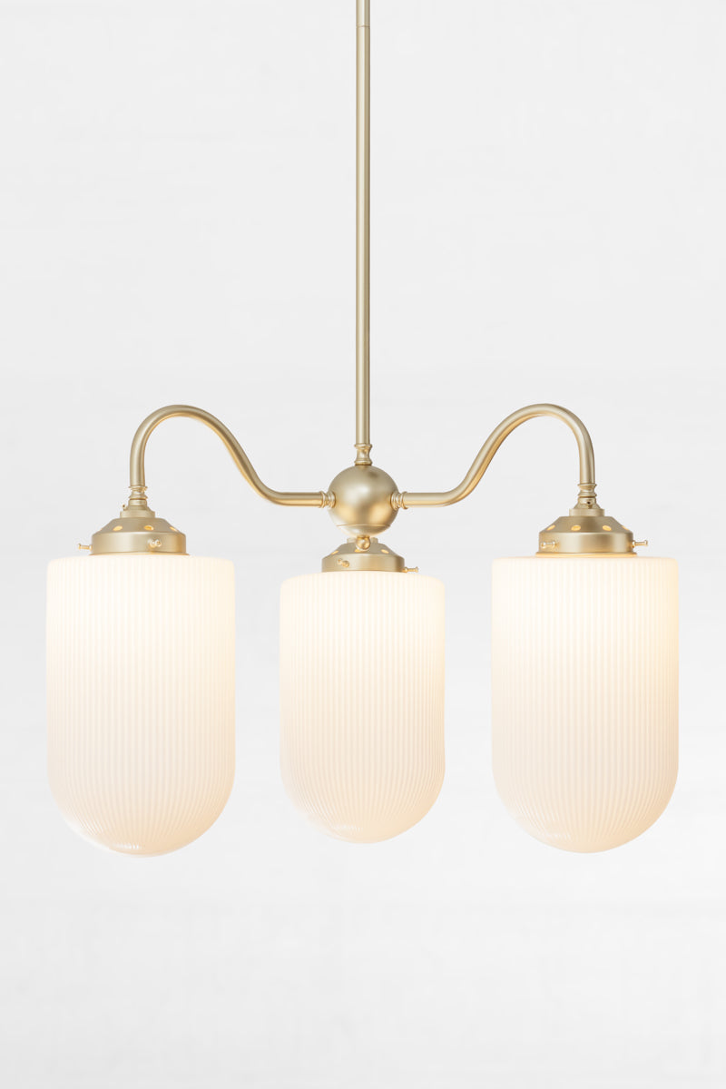 Gold/brass triple arm gooseneck chandelier with large reeded opal glass shades. 