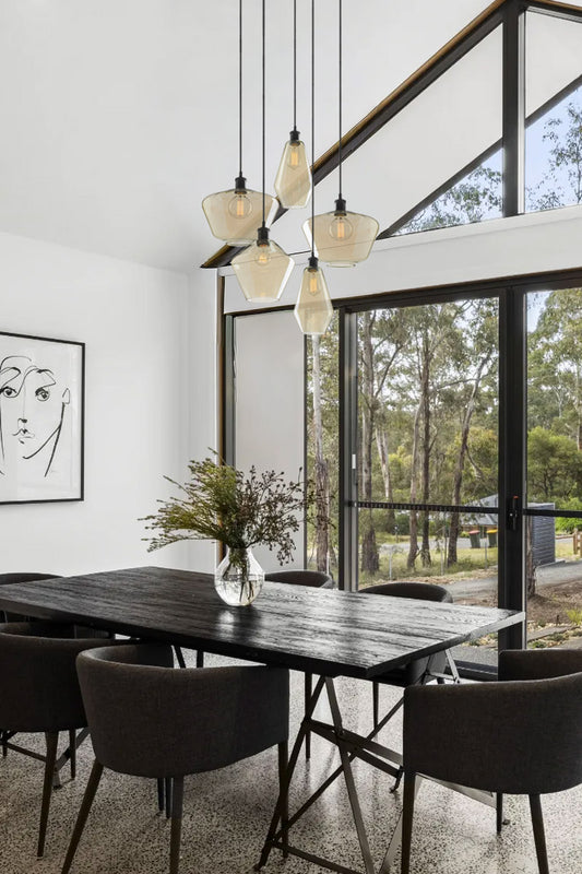 5 chanmpagne glass shades in variouse designs on a modern dining table. 