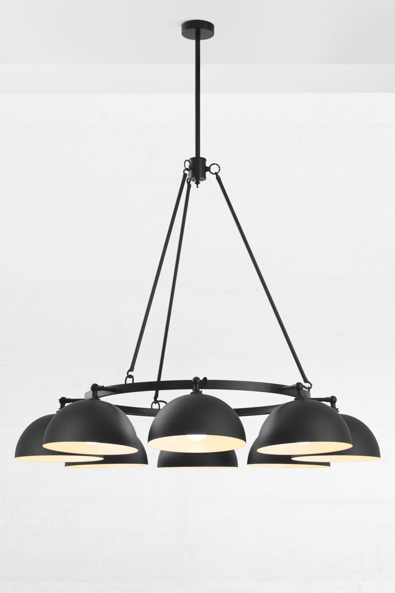 Black eight light chandelier with black dome shades facing down. 