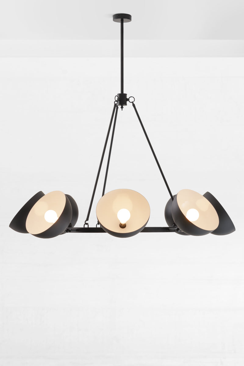 Black eight light chandelier with black dome shades facing up and out. 