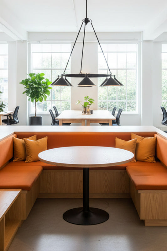 Modern office interior with orange benches, featuring a modern chandelier with eight black cone shades for task lighting