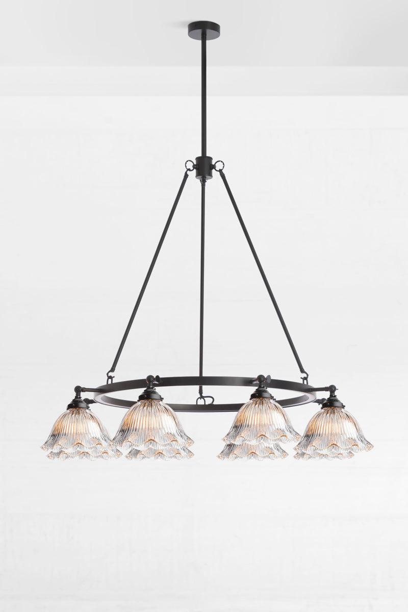 Clear ribbed glass shades on an 8 light black circular chandelier. 