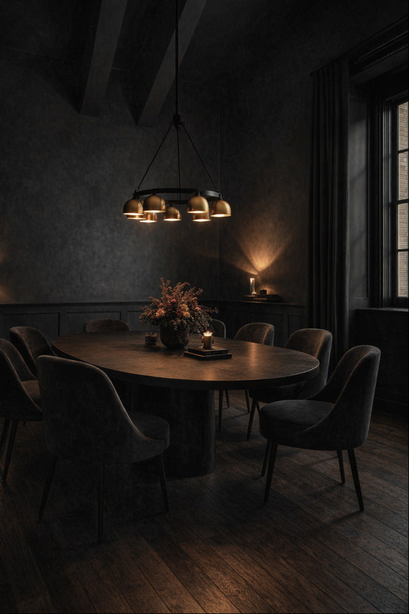 Black Circular chandelier with gol/brass bulb shades over a dinig space in a moody room. 