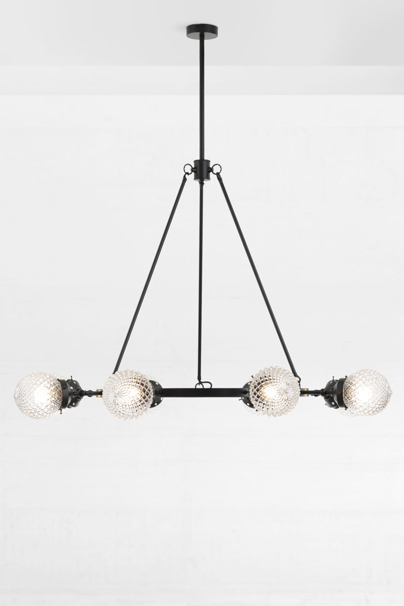 Black circular 8 light chandelier with clear glass orb shades and lampholders face out.
