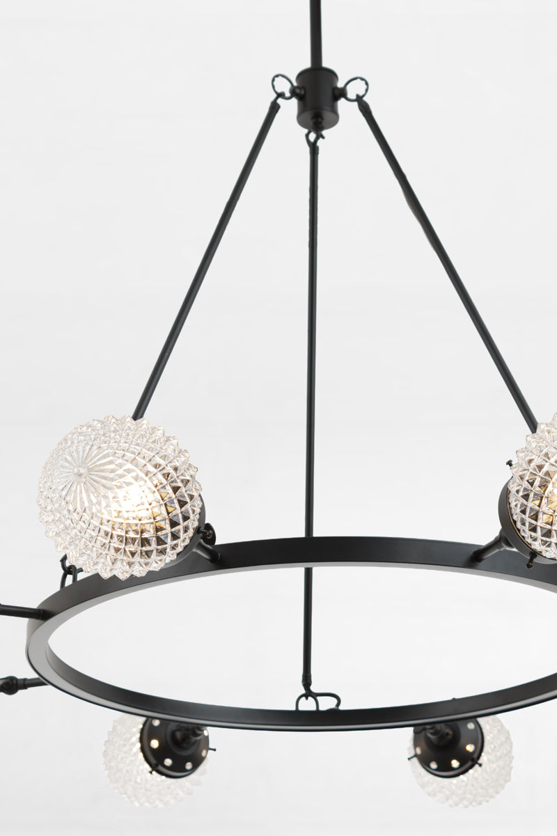Close up of the vintage design on the clear glass shades of the circular chandelier. 