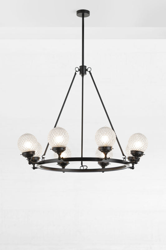 Black circular 8 light chandelier with clear glass orb shades and lampholders face up. 