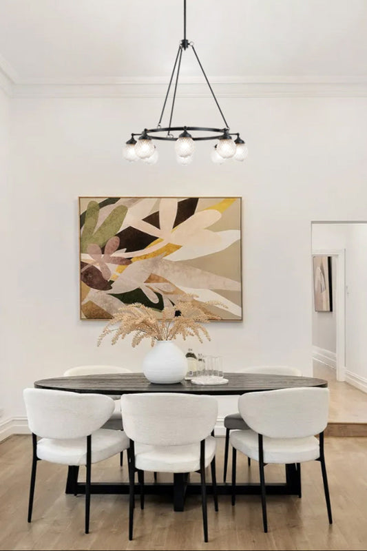 8 light circular chandelier with glass ball shades over a modern dining space. 