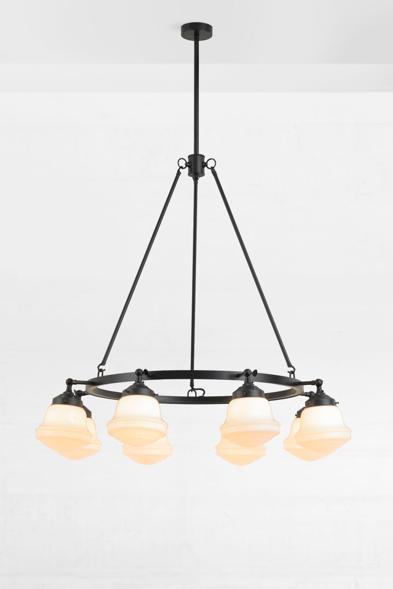 Black circular chandelier with 8 adjustable lampholders facing downwawrds, paired with 8 opal schoolhouse style shades. 