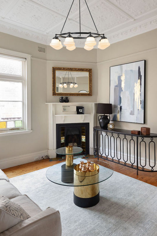 Eight light black circular chandelier with schoolhouse style opal shades in a contemporary heritage living room. 