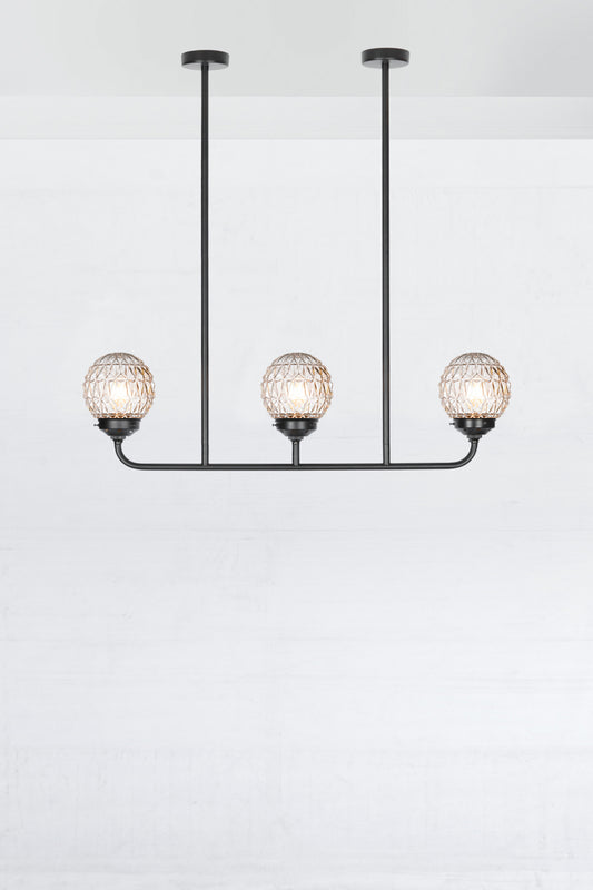 Three light linear chandelier in black with clear glass ball shades with a Geometric pattern.