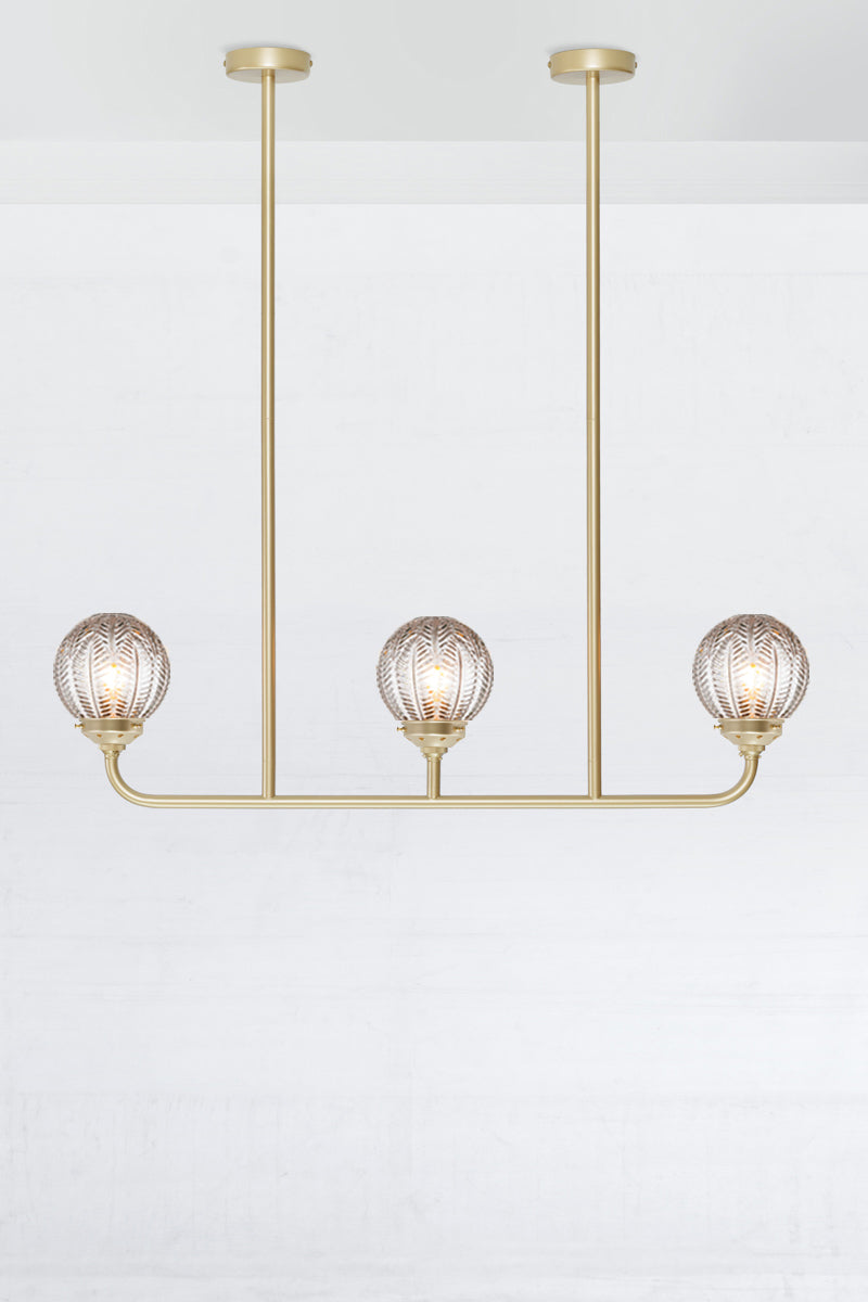Gold/brass 3 light linear chandelier with clear glass ball with vintage designs. 