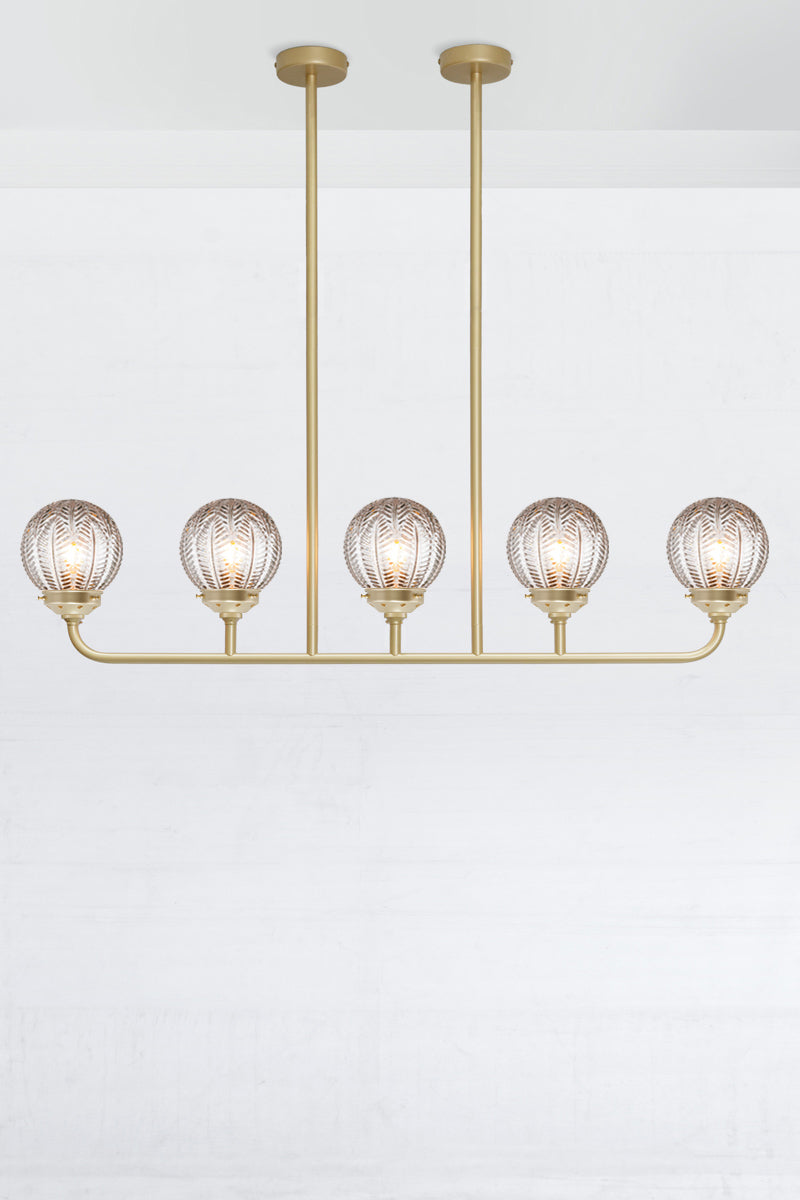 Gold/brass 5 light linear chandelier with clear glass ball with vintage designs. 